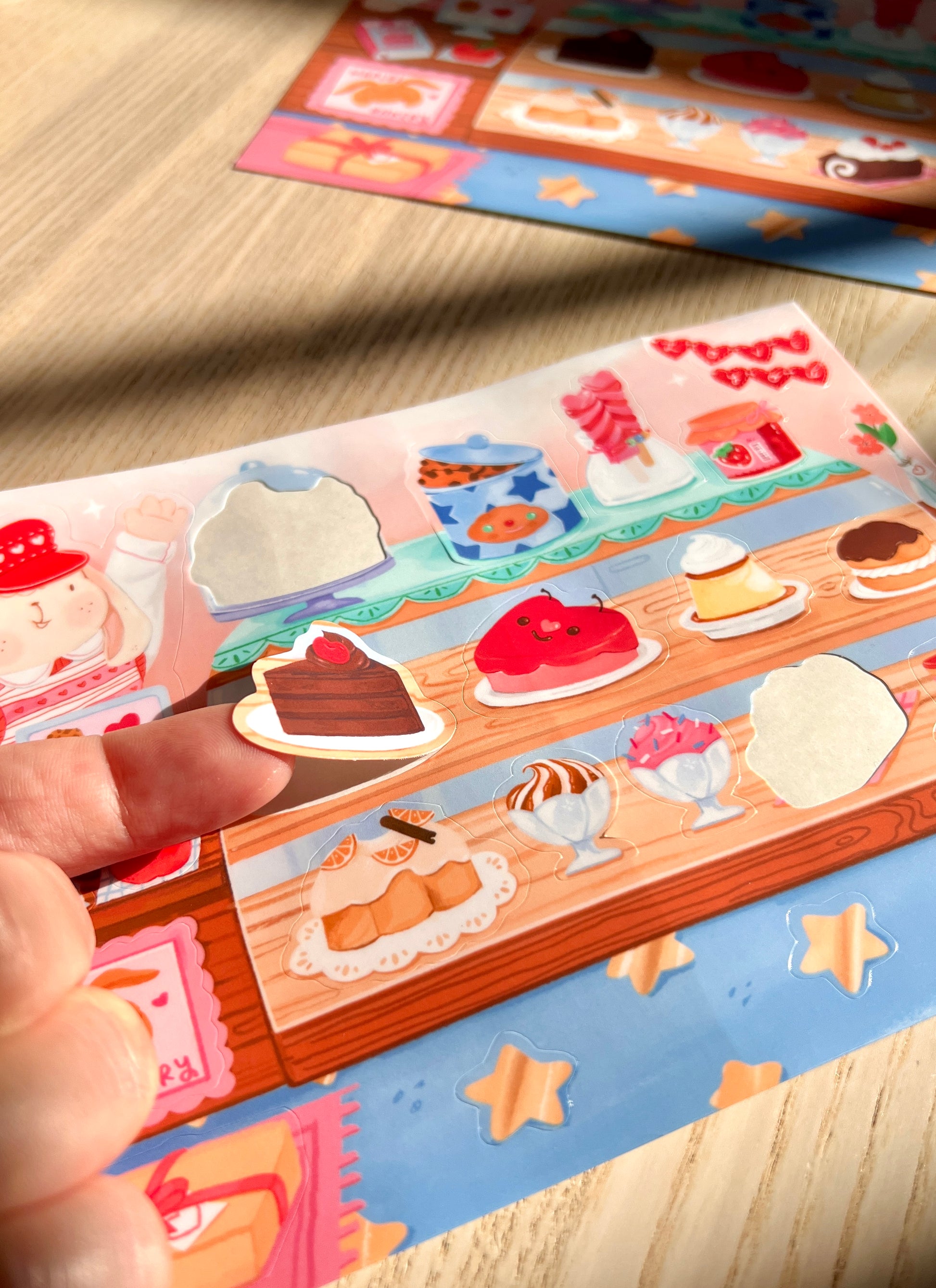 Decorative stationery items with cartoon characters and food illustrations on a wooden surface.