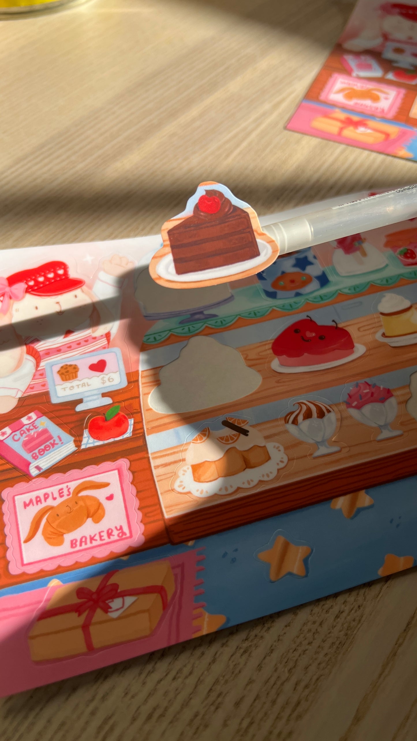Colorful chocolate cake sticker peeled from sticker sheet on a wooden surface