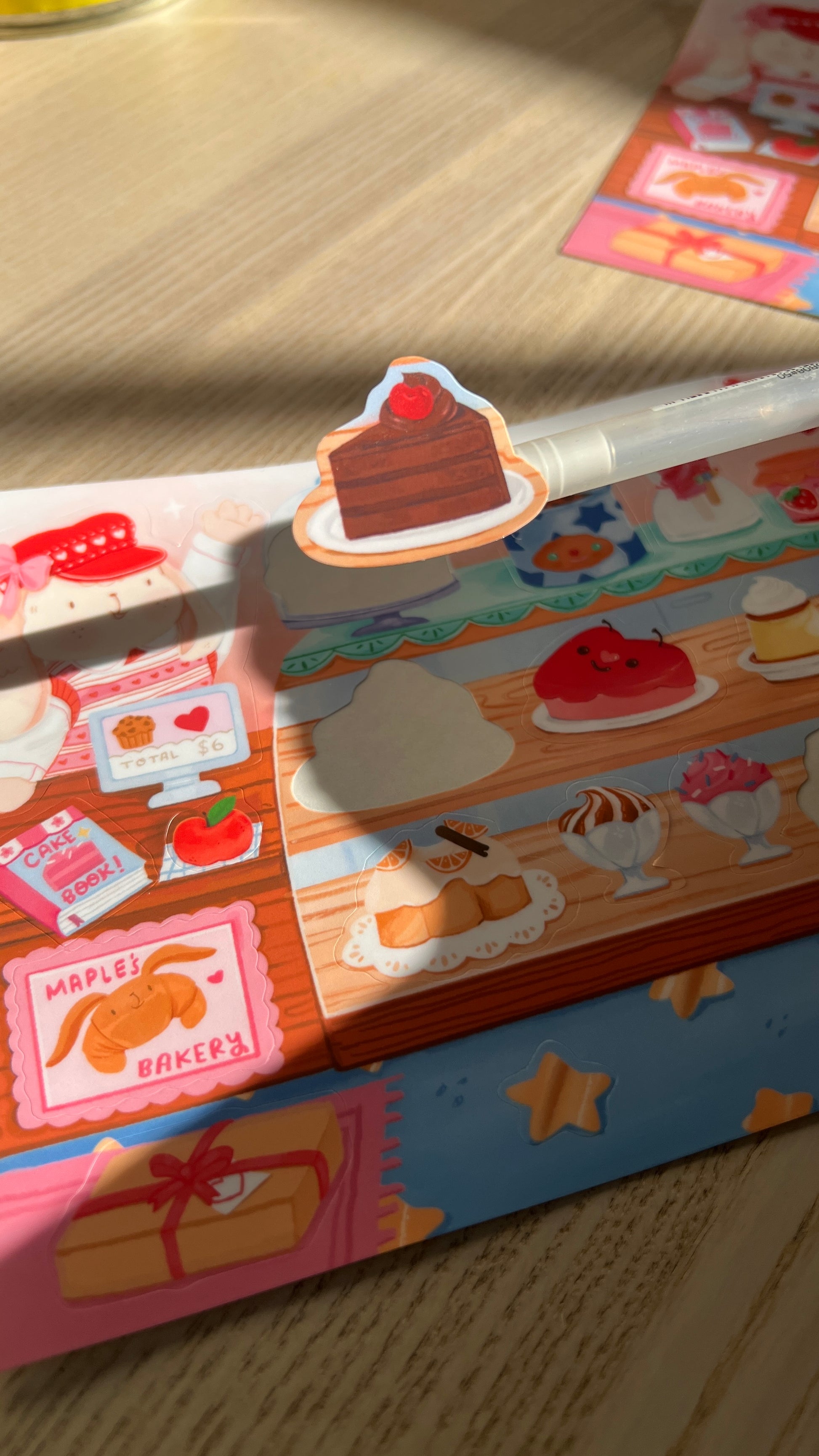 Colorful chocolate cake sticker peeled from sticker sheet on a wooden surface